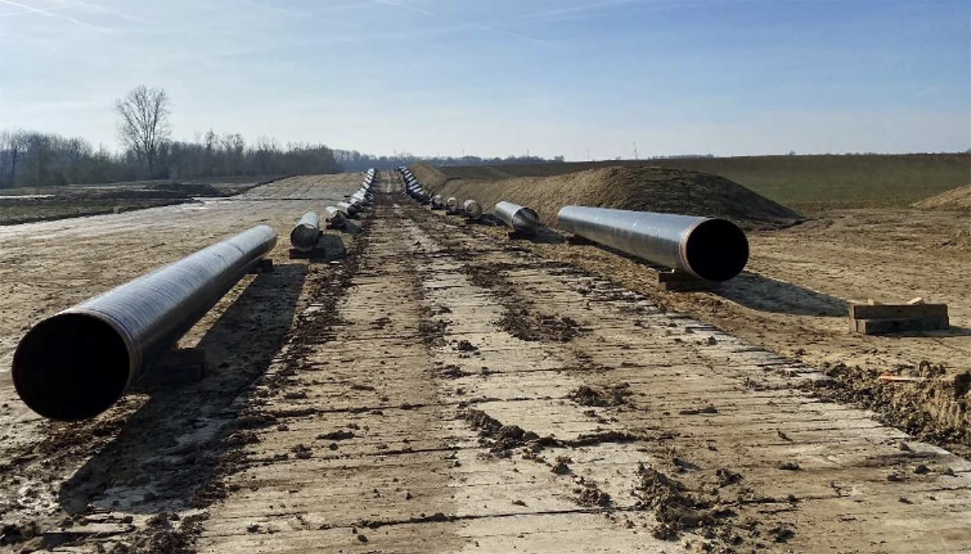 Le chantier en ligne à Nesle : piste protégée, cordons de terre et tubes DN 750/DN 900 bardés de part et d’autre de la piste.