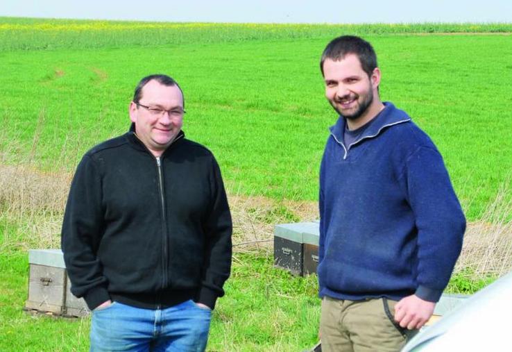 Patrice Payen, agriculteur à Fléchy (60) et Benoît Minart dans un petit rucher installé près d’une parcelle de colza en début de floraison. 
Patrice a remarqué une augmentation moyenne du rendement du colza de 6 à 7 quintaux/ha depuis la présence de ruches, simplement grâce à une meilleure pollinisation des plantes.