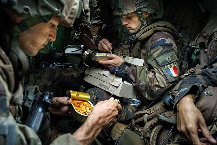 Photo d’Édouard Élias montrant des légionnaires français mangeant leur ration dans leur VAB.
