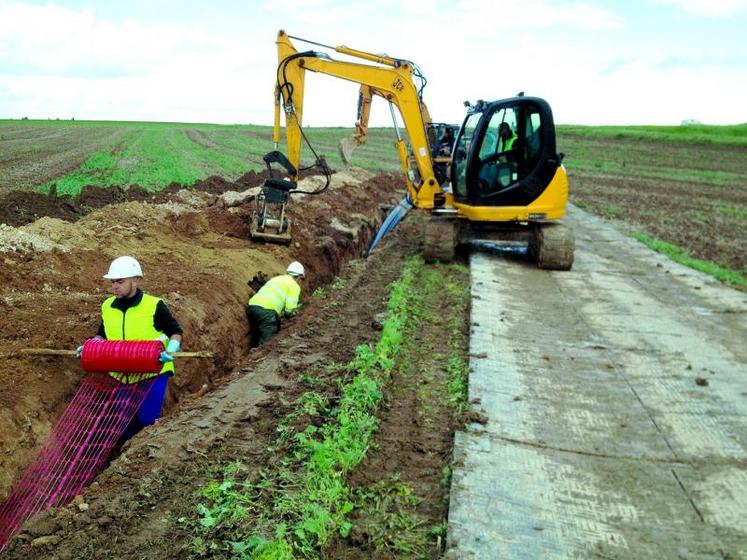 La pose à la trancheuse est théoriquement plus rapide, mais la tranchée traditionnelle avec piste protégée est moins sensible aux conditions humides.