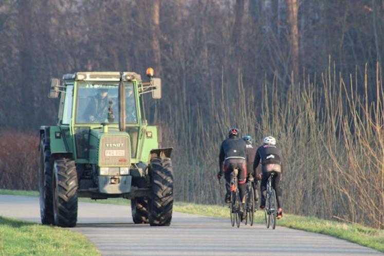 franchissement d'une ligne blanche sur la route derrière un tracteur