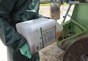 Un agriculteur verse un herbicide dans son pulvérisateur