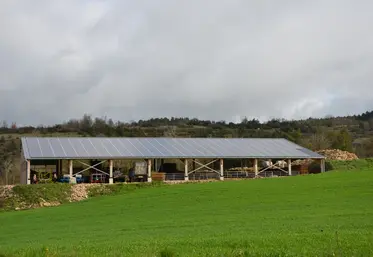 Des panneaux solaire sur un bâtiment agricole à proximité d'un champ
