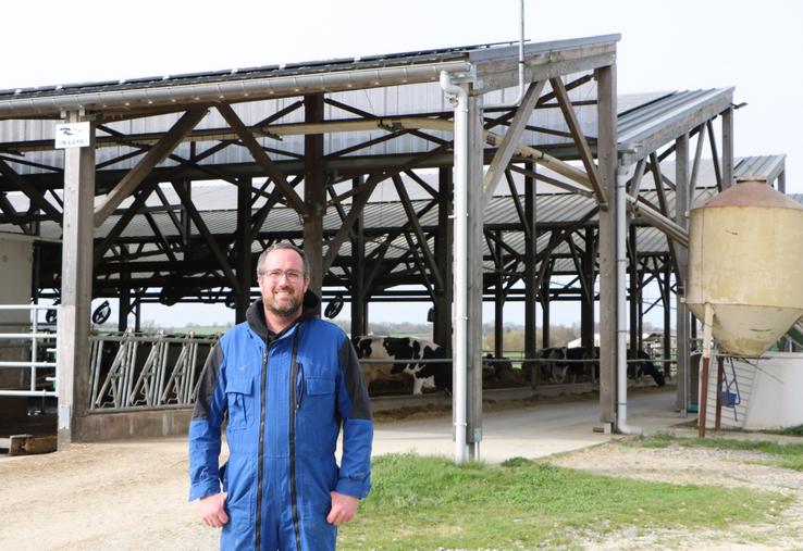 Maxime Gourand, l'un des trois associés du Gaec Le Bré Ménard, devant le bâtiment en toit usine mis en service en juillet 2022.