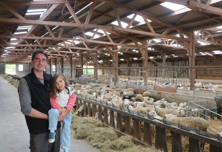 Thomas Courcier, ici avec sa fille dans les bras : "L'avantage d'un bâtiment ovins, c'est qu'il vieillit bien."