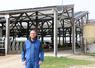 Maxime Gourand, l'un des trois associés du Gaec Le Bré Ménard, devant le bâtiment en toit usine mis en service en juillet 2022.