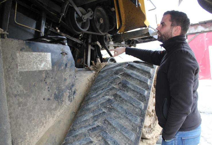 Alexandre Martin attend la fin du gel pour passer le karcher dans une batteuse qui a été partiellement démontée.