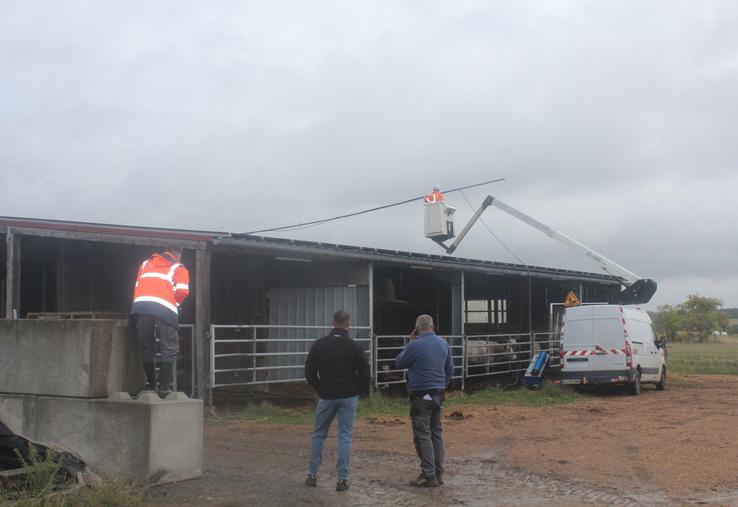 Un deuxième salarié (ici en orange) supervise et sécurise la manoeuvre de son collègue sur le toit.