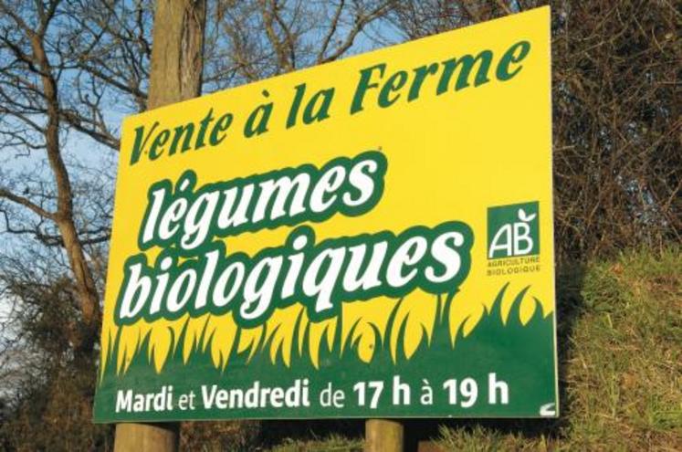 Pancarte à l'entrée d'une exploitation agricole produisant des légumes biologiques.