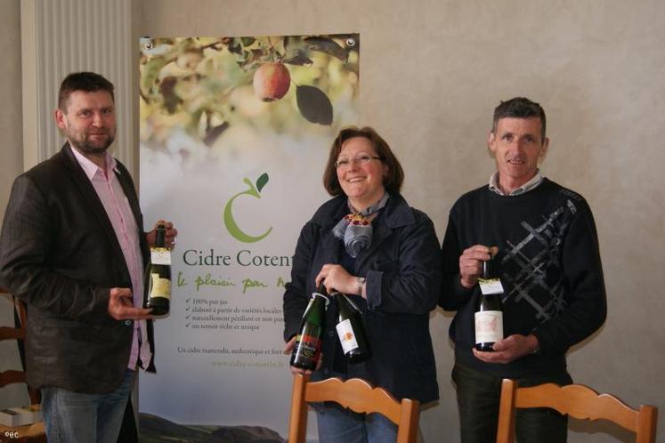 Marie-Agnès Hérout (au centre) présente l'un des aspects de la promotion du Cidre du Cotentin, une collerette d'identification sur chaque goulot de bouteille commercialisée.
