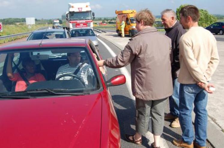 Distribution aux automobilistes de produits laitiers au rond point de l'A 84 à Guilberville vendredi matin.