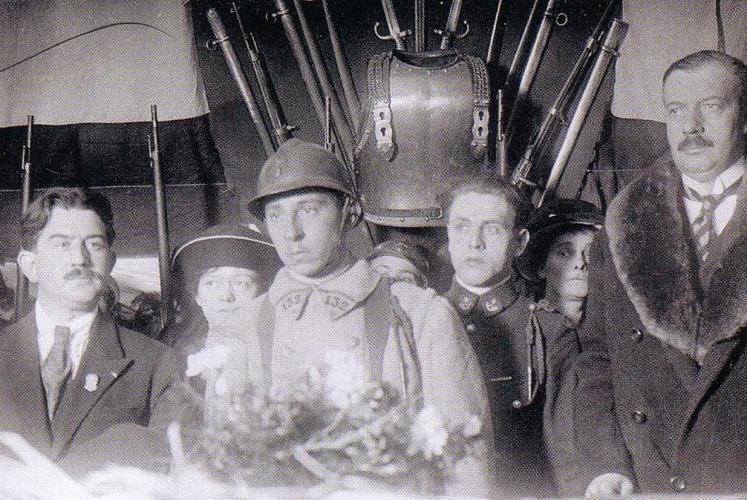Le caporal Auguste Thin, ému, le 10 novembre 1920 à Verdun. André Maginot, Ministre des Pensions et des Blessés de Guerre (à droite) lui a remis le bouquet d’oeillet. Il le pose sur le 6è cercueil.