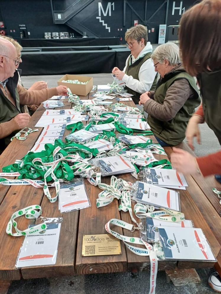 Les bénévoles en pleine préparation des accréditations de chacun. Un travail de longue haleine qui facilitera l'intégration de tous les jours J.