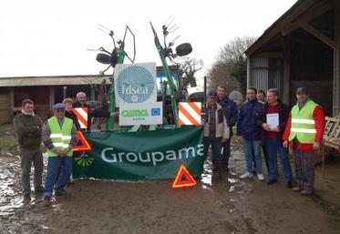 Un tracteur nouvellement équipé de la signalétique obligatoire au 1er mars et les partenaires de l’opération.
