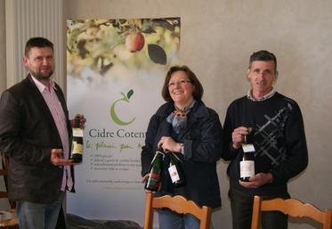 Marie-Agnès Hérout (au centre) présente l'un des aspects de la promotion du Cidre du Cotentin, une collerette d'identification sur chaque goulot de bouteille commercialisée.