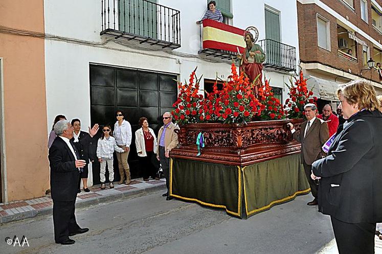 Des femmes guettent au balcon l'arrivée de la procession.