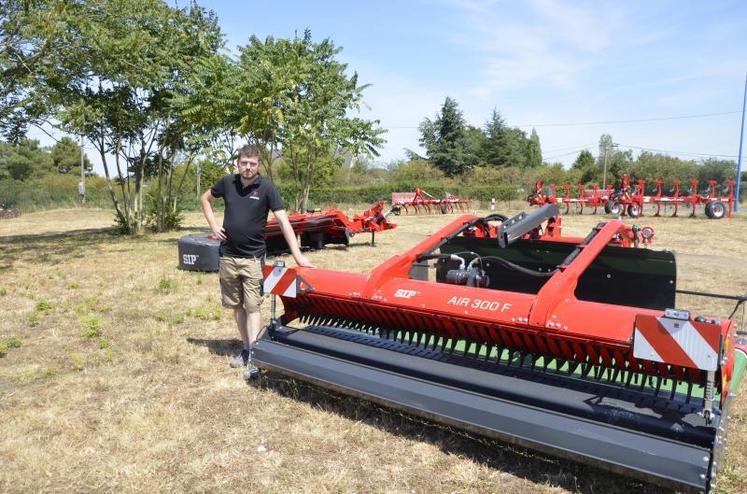 Nicolas Mensen à côté de l’andaineur frontal à tapis du constructeur slovène Sip, proposé par Négo-Cérémat. Largeur de travail : de 3,60 m à 4,50 m.