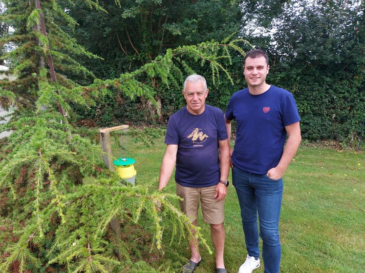 Raymond Vincent et Antonin Grimault-Fremy de la FDGDON49, devant un piège à phéromones pour les papillons de chenilles processionnaires du pin.