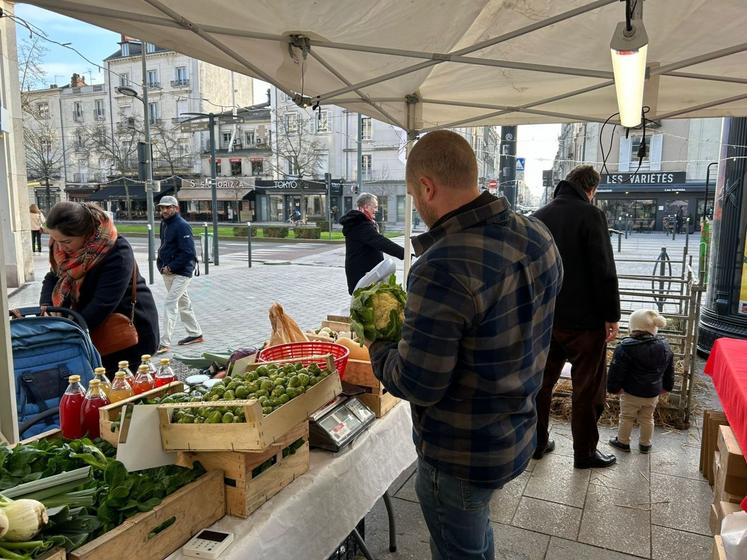 Un producteur local de fruits et légumes échange avec les visiteurs, mettant en avant des produits frais et de saison issus du terroir angevin.