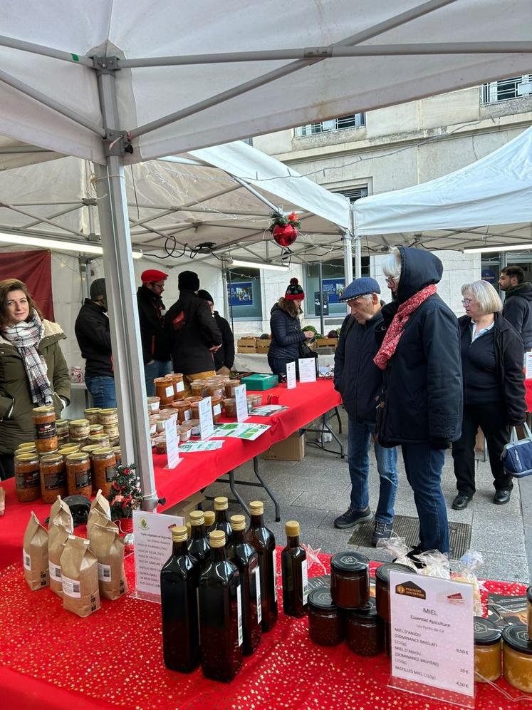 Des visiteurs curieux découvrent les produits du marché, un moment privilégié pour échanger avec les producteurs.