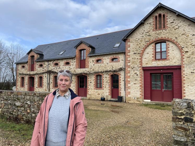 Jacqueline Cottier devant le hameau du bois, soit un ensemble de six appartements créés dans une ancienne stabulation.
