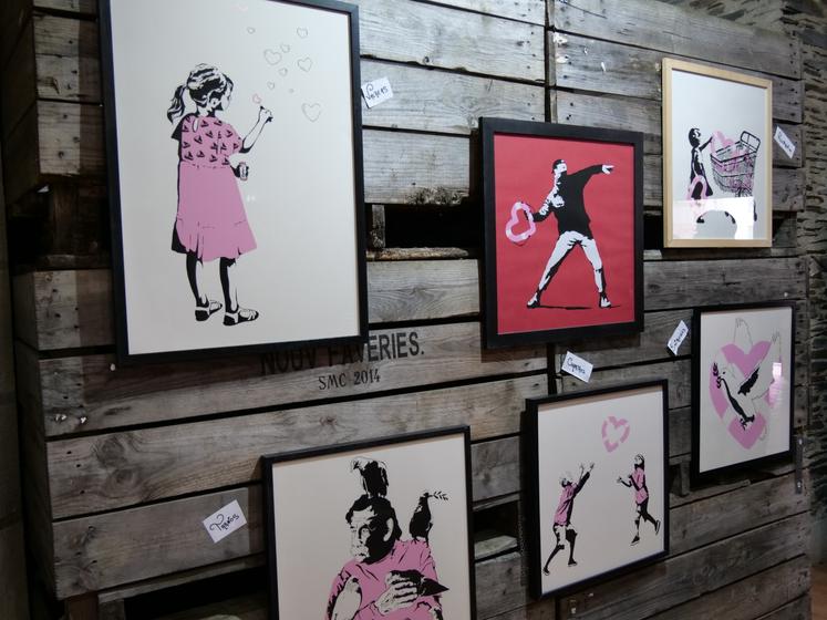 Accrochées sur des palox en bois de la coopérative des Vergers d'Anjou, partenaire de l'événement, plus de 250 sérigraphies de l'artiste Banksy sont abritées au sein de la Collégiale Saint-Martin, à Angers.