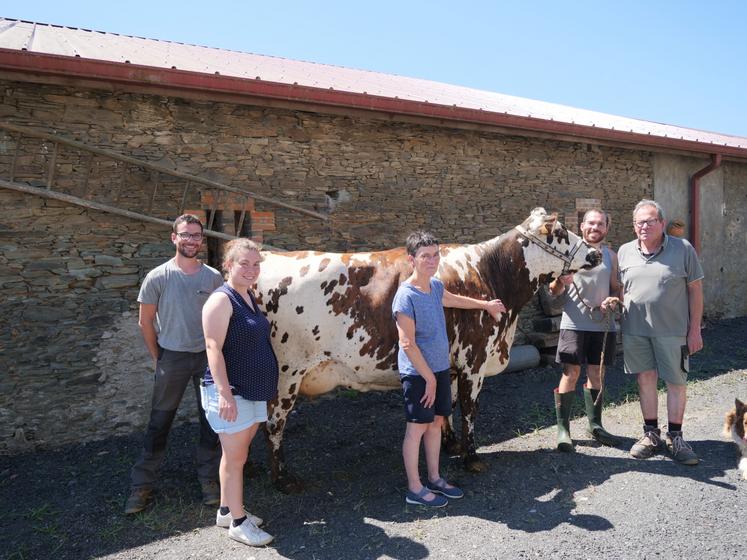 La famille pose avec Tomate, une vache en deuxième lactation, fille de Picasso, qui a remporté le prix de championnat génisse en 2024 à Festi'élevage.