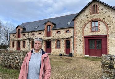 Jacqueline Cottier devant le hameau du bois, soit un ensemble de six appartements créés dans une ancienne stabulation.