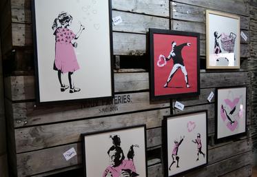 Accrochées sur des palox en bois de la coopérative des Vergers d'Anjou, partenaire de l'événement, plus de 250 sérigraphies de l'artiste Banksy sont abritées au sein de la Collégiale Saint-Martin, à Angers.