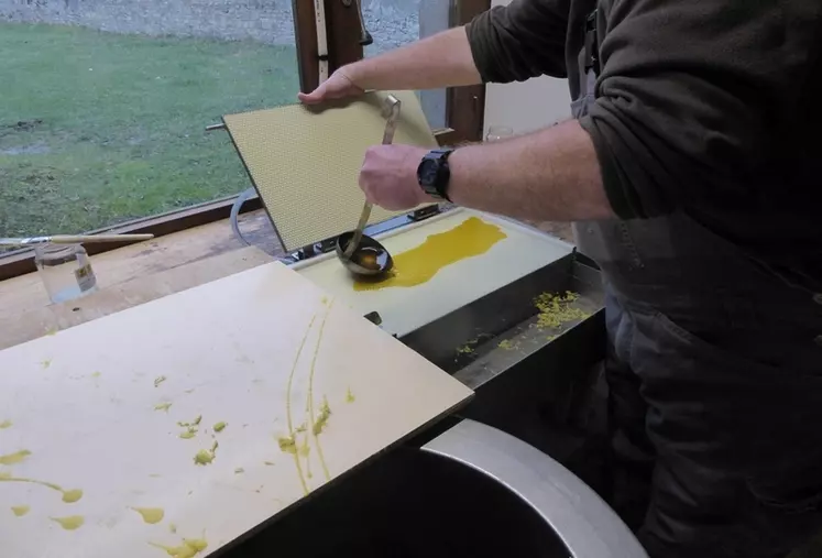 La cire chaude est répartie dans le gaufrier.