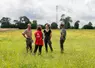 groupe de quatre personnes discutant dans une prairie