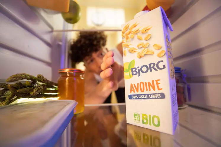 Jeune garçon prenant un paquet d'avoine bio à la marque Bjorg dans son frigo