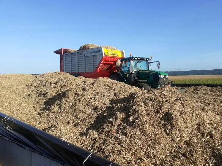 <em class="placeholder">Tracteur John Deere 6R215 et remorque autochargeuse Pöttinger Jumbo 8400 déchargeant la paille de maïs sur un silo</em>