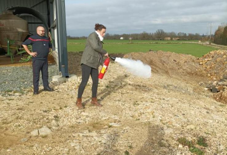 La manipulation des extincteurs (ici, Cécile Rimbaud) comprend plusieurs étapes et est différente selon les modèles utilisés.