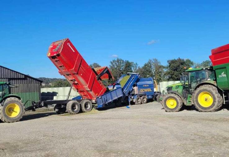 Le combiné presse-enrubanneuse est posté dans la cour de la ferme, où les bennes viennent vider le fourrage.