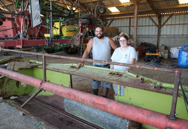 Une barre de coupe d'une ancienne moissonneuse est en train de devenir un tournebroche géant.