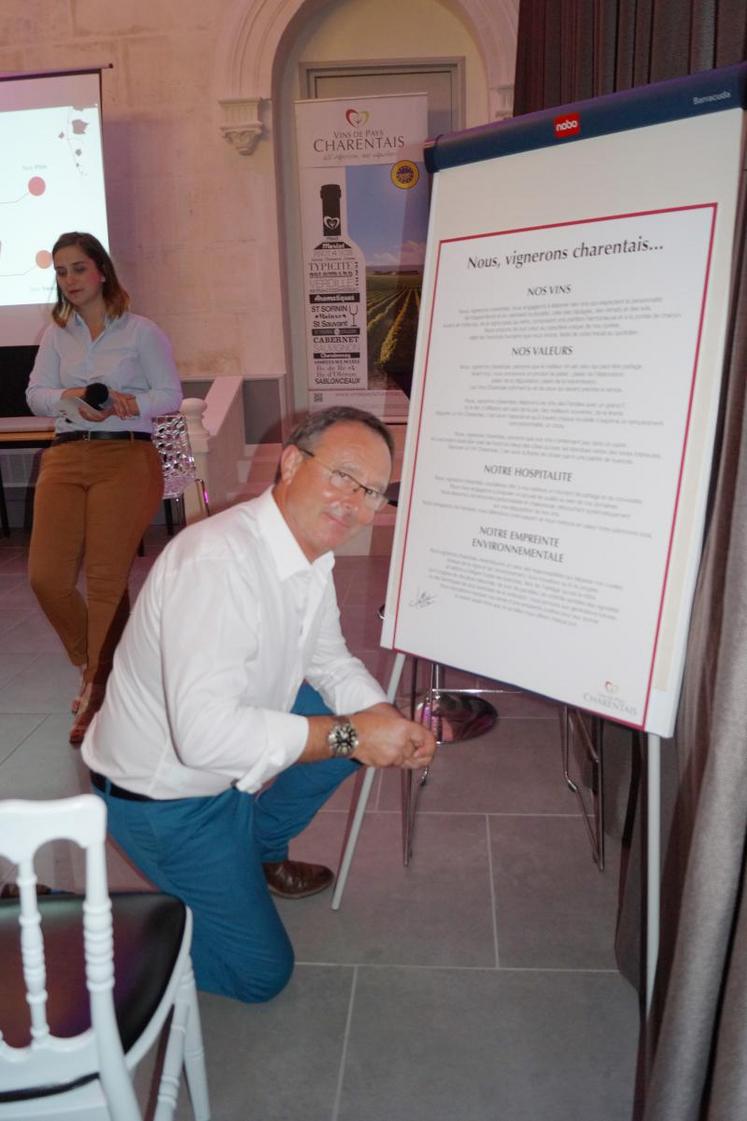 Thierry Jullion, président du SPPVPC, signe la charte des vignerons, présentée par Chloé Imbert (en arrière-plan).