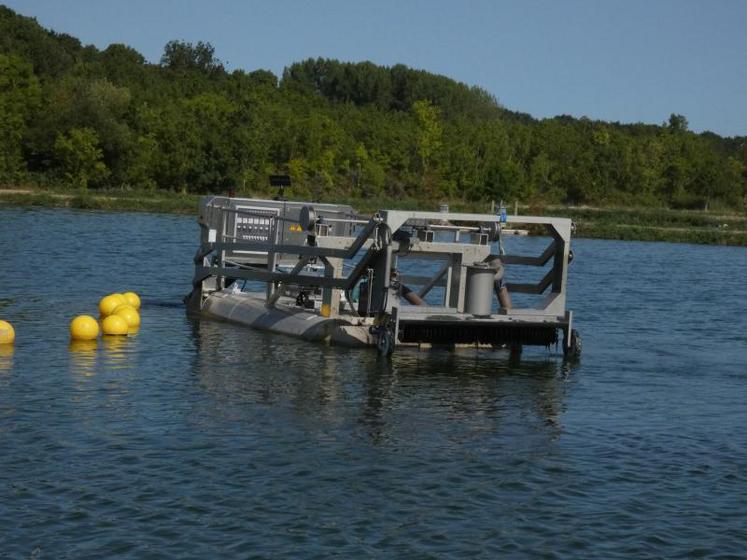 Guidée depuis la berge, la barge suit un circuit pré-établi par des études balistiques et extrait les boues de la bassine de décantation des eaux usées.