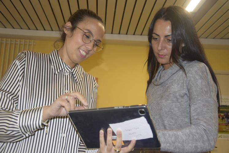 Nora Ouassime présente à sa collègue le fonctionnement d’une tablette.