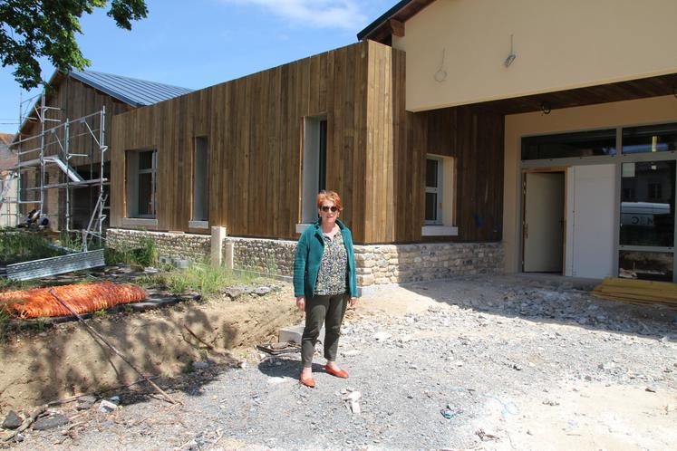Claudie Beauvais, maire de Valdivienne, devant le futur pôle commercial de la commune. La façade est bardée de bois et recouverte des pierres récupérées à la déconstruction de l'école privée.