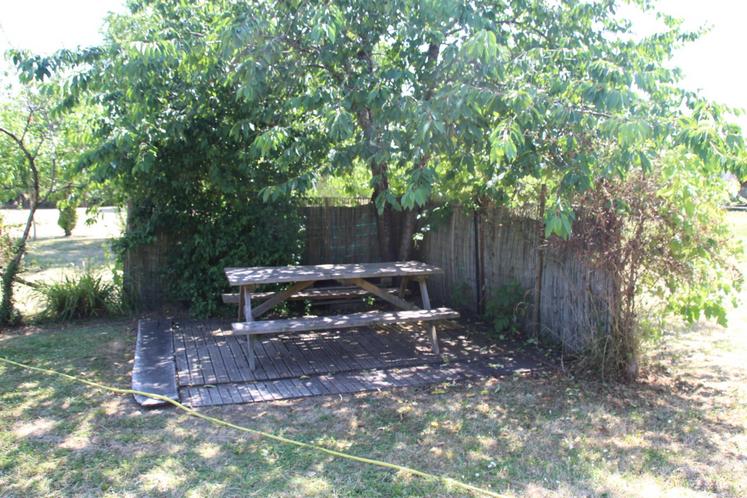 La maison bénéficie d'un grand espace de verdure, où une table de pique-nique permet des repas en pleine nature.