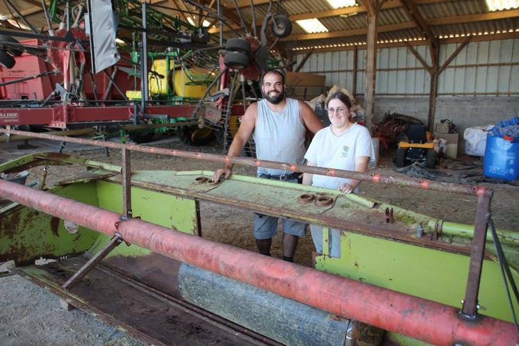 Une barre de coupe d'une ancienne moissonneuse est en train de devenir un tournebroche géant.