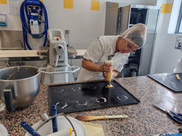 Une apprentie pâtissière à l'essai des choux.