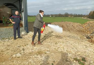 La manipulation des extincteurs (ici, Cécile Rimbaud) comprend plusieurs étapes et est différente selon les modèles utilisés.