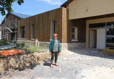 Claudie Beauvais, maire de Valdivienne, devant le futur pôle commercial de la commune. La façade est bardée de bois et recouverte des pierres récupérées à la déconstruction de l'école privée.