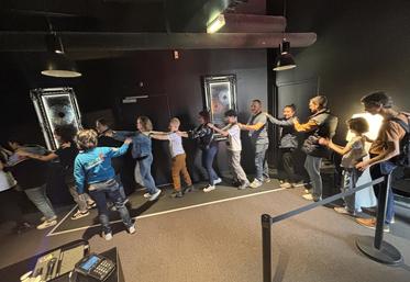 Les visiteurs déambulent en file indienne pour découvrir dans le noir complet la forêt du Zanzibar, Tokyo et la Cordillère des Andes.