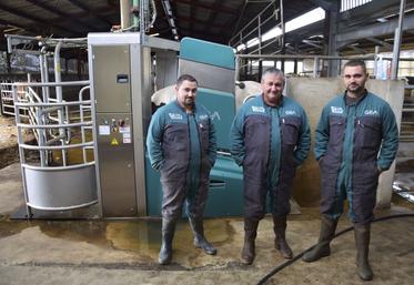 Patrick Chargy, au centre, pose avec ses fils Joachim et Aurélien, devant l'un de leurs deux robots de traite GEA.