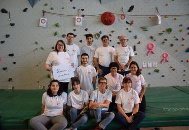 Quelques-uns des 50 bénévoles de Grimpe rose, lors de la préparation du week-end de sensibilisation au cancer du sein qui avait lieu les 11 et 12 octobre, autour des thématiques du dépistage, du bien-être ou de l'accompagnement social. Adam Abbas se situe au fond, 2e à gauche. Nathalie au premier rang, 3e à gauche.