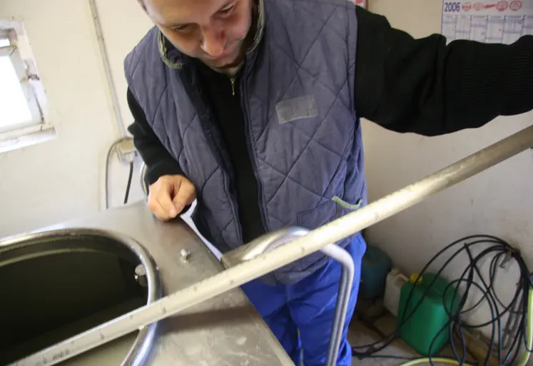 Un chauffeur-ramasseur mesure la quantité de lait de chèvre dans un tank lors de la collecte.