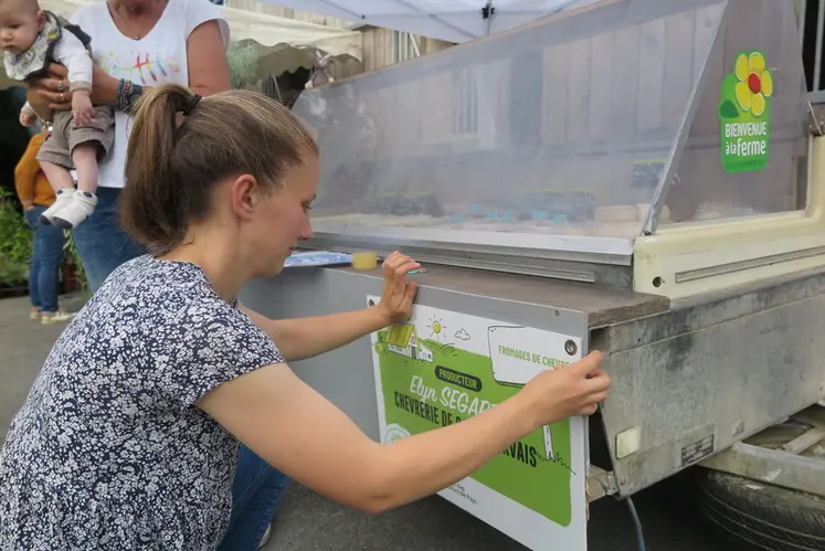 <em class="placeholder">Une fromagère fermière installe une affichette d'identification</em>